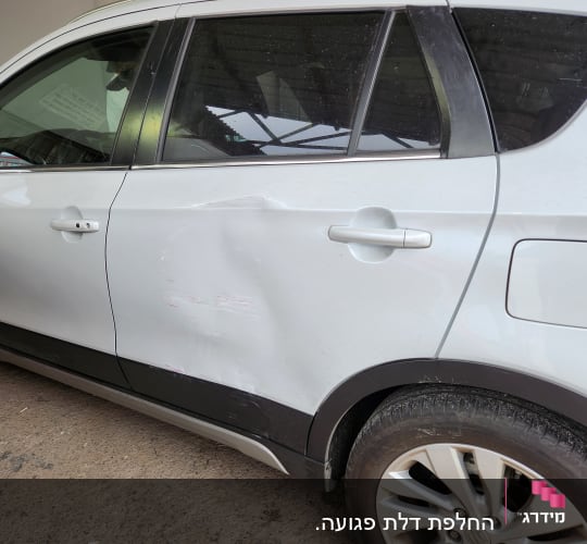 מכונית לבנה עם פגיעת פח בצד הדלת האחורית